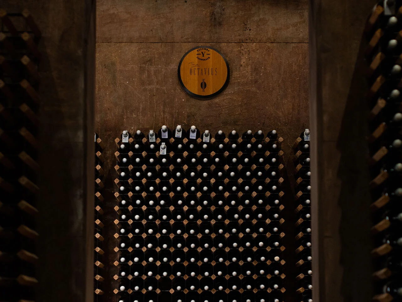 Yalumba cellar wall with Octavius barrel head logo and stored wine bottles in special racks