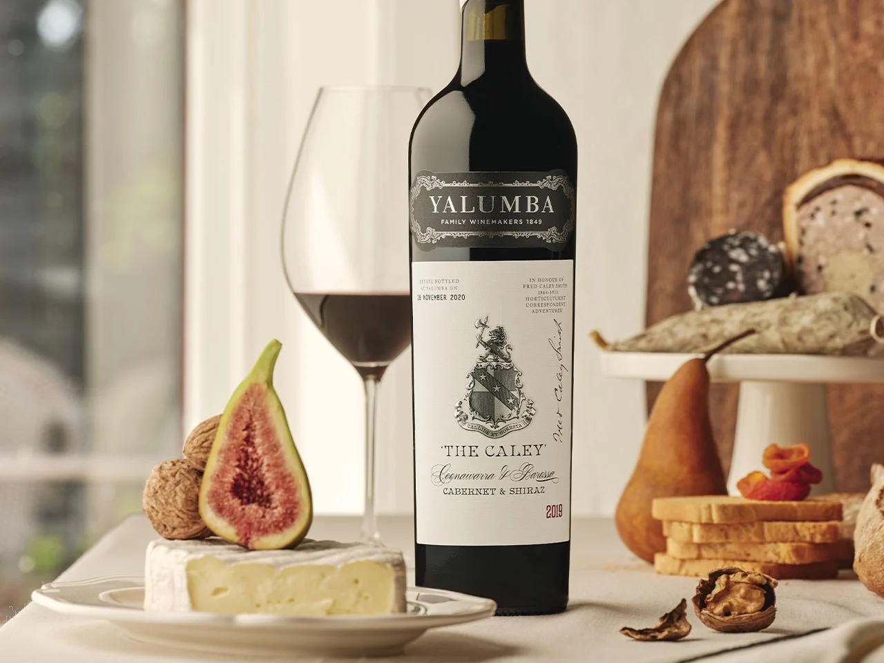 The Caley Cabernet & Shiraz bottle with wine glass and fresh fig on cheese board