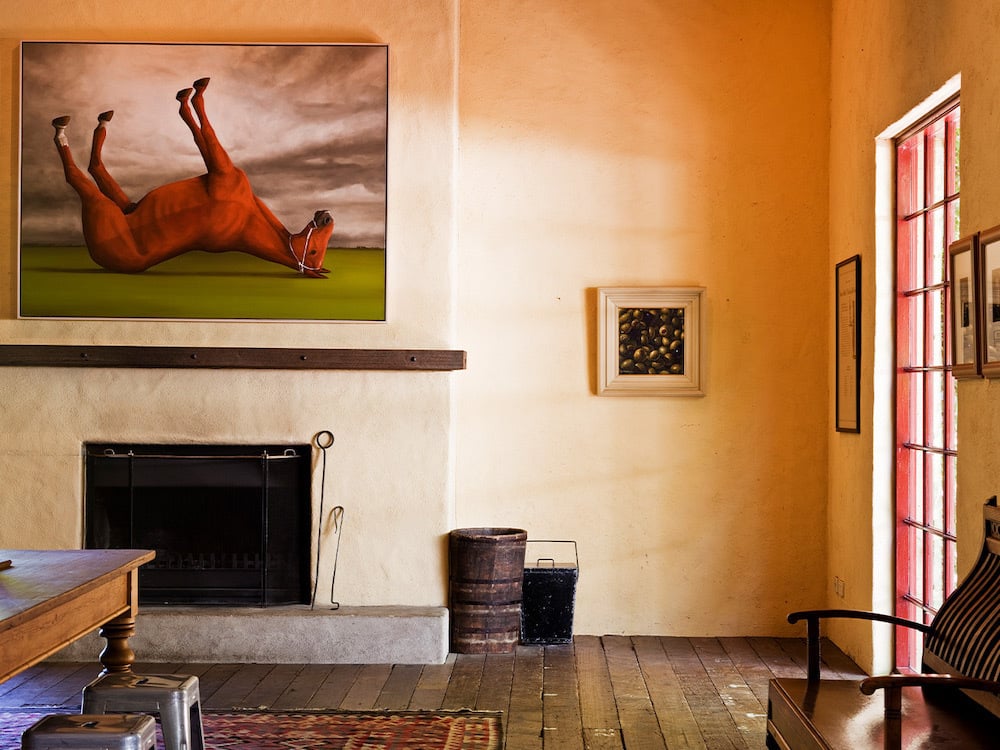 A view from inside the wine room, where you'll see a painting of an upside-down horse sitting over the top of a fire place