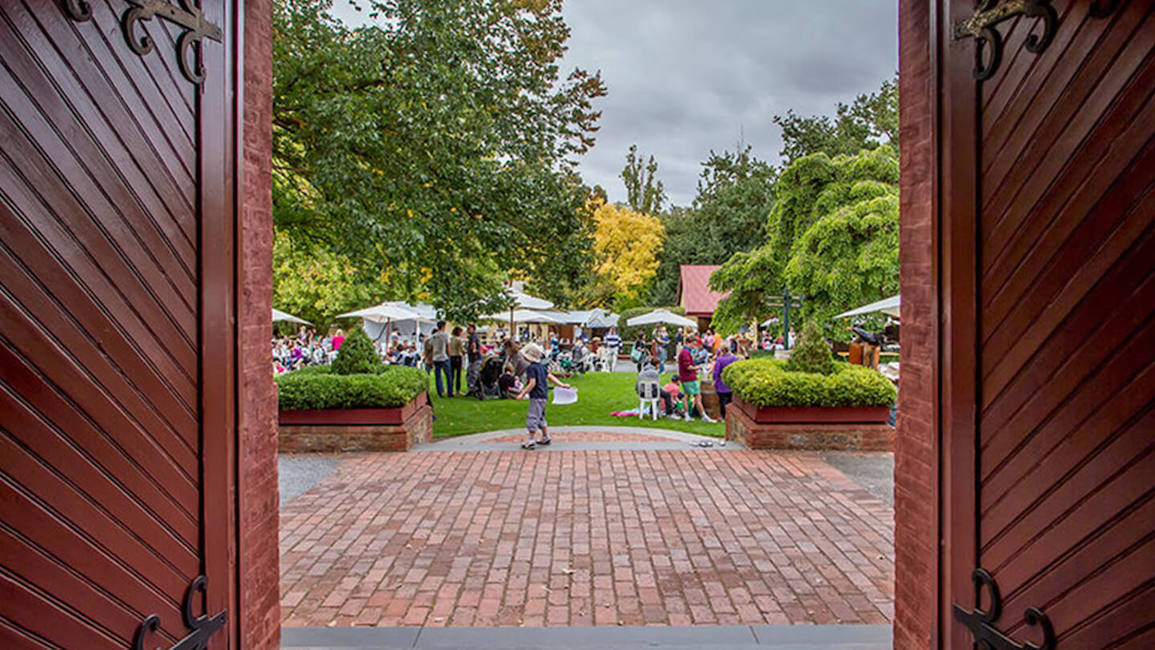 Looking out through the big red doors onto the lawn at Yalumba, seeing families enjoying their time