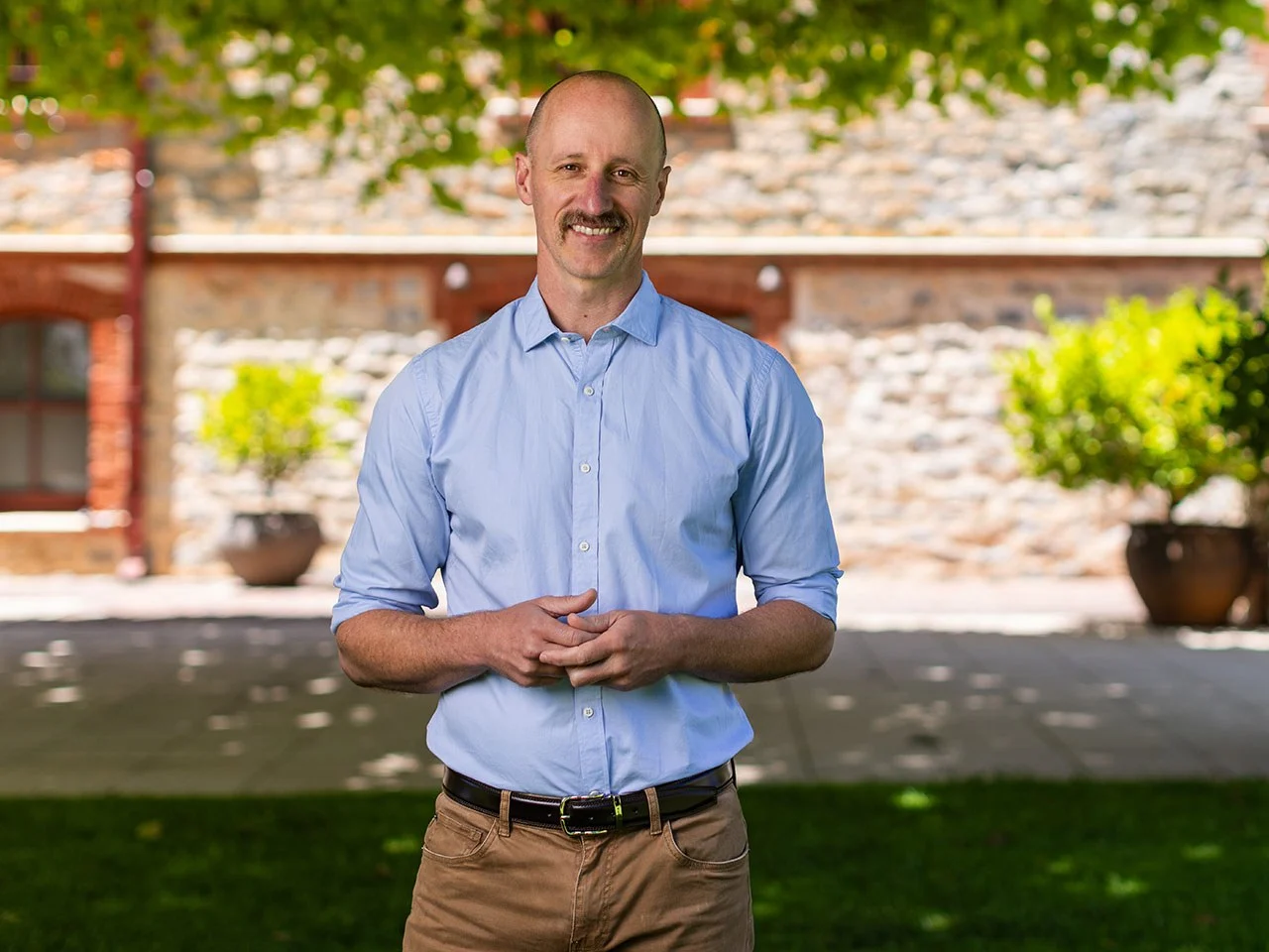 Sam Wigan, Yalumba Head Winemaker, standing in blue shirt outdoors at the winery