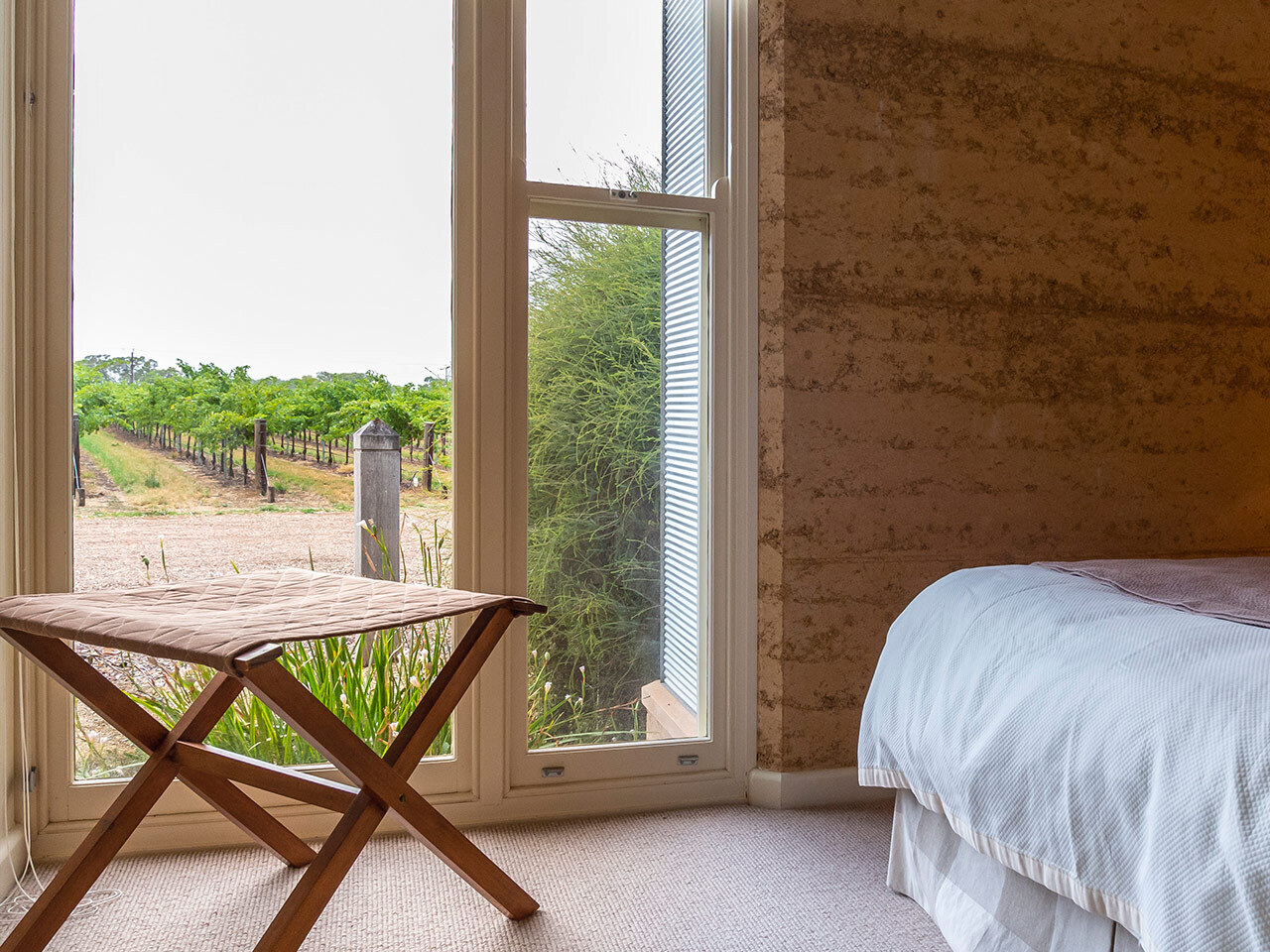 A view outside the window of the bedroom, showing green vinyards
