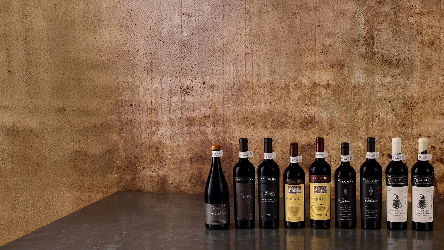 A close up view of a 1962 vintage bottle sitting amongst others in a dusty cellar