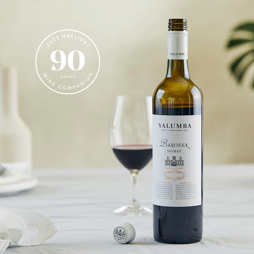 Barossa Shiraz bottle with wine glass and Halliday 90 points award on white table