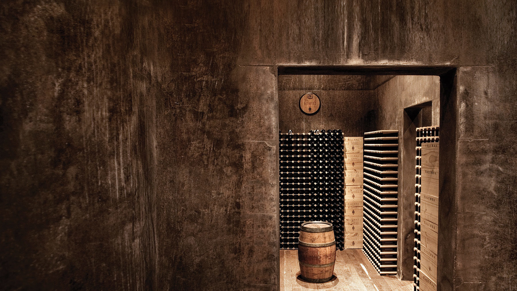 A classy wine cellar with a barrel sitting in the middle