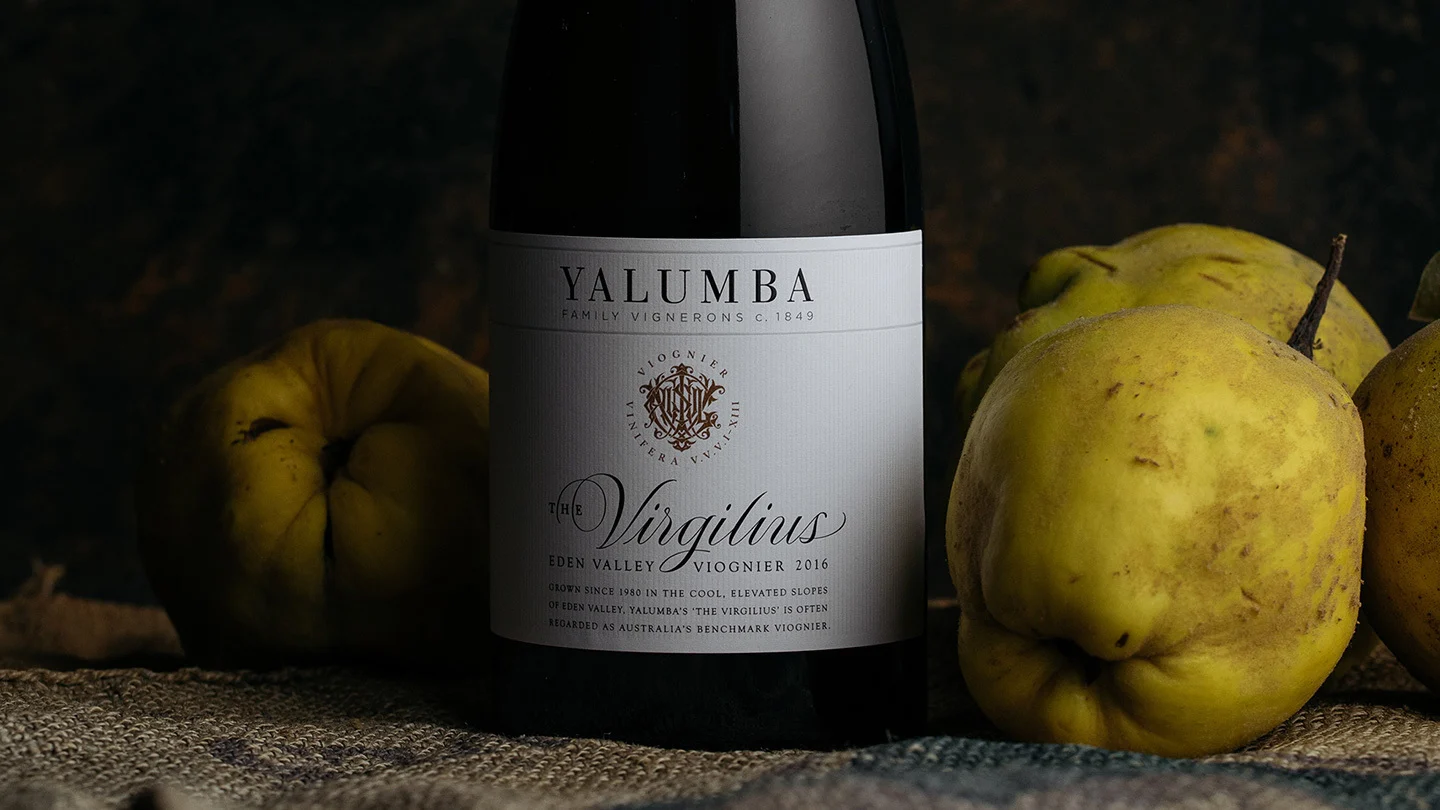 Bottle of The Virgilius Eden Valley Viognier with yellow quinces against dark background